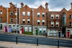 Terrace houses on a decending road with different colour of front doors